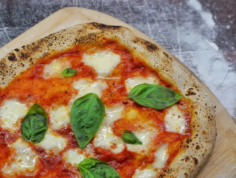 pizza with green leaf on top | Photo by amirali mirhashemian, on https://unsplash.com/@amir_v_ali?utm_source=centralapp&utm_medium=referral