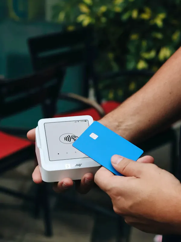 A person holding a white box with a blue card in it | Photo de SumUp, sur https://unsplash.com/@sumup?utm_source=centralapp&utm_medium=referral