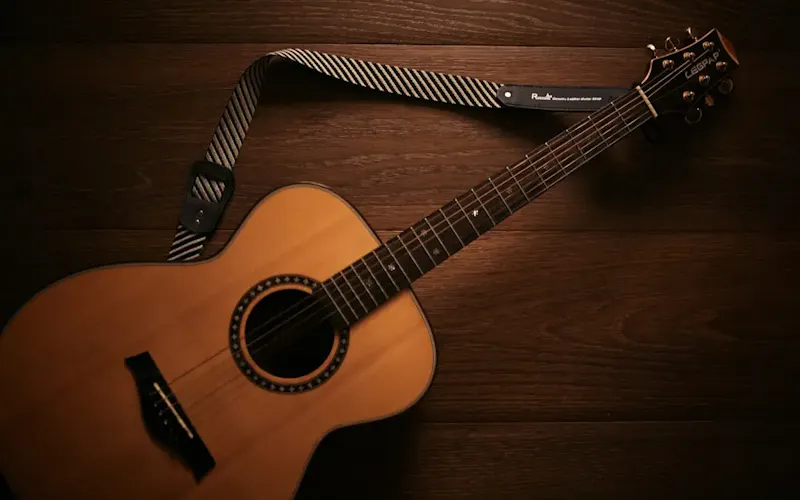 brown acoustic guitar on brown wooden floor | Photo de De an Sun, sur https://unsplash.com/@andyadcon?utm_source=centralapp&utm_medium=referral