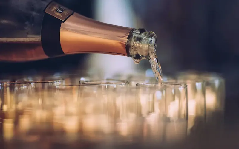 Image of Matka a bottle of champagne being poured into a glass | Photo by Mads Eneqvist, on https://unsplash.com/@madseneqvist?utm_source=centralapp&utm_medium=referral