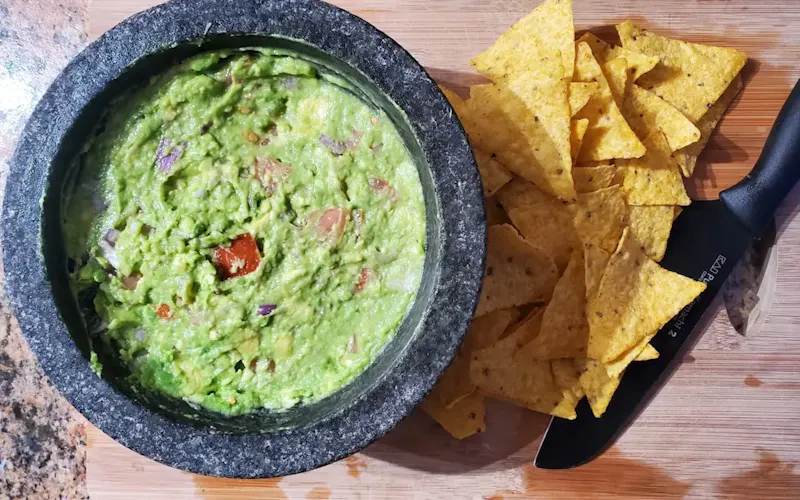 Image of Rishi's in Slate And Grain Brasserie & Bar a bowl of guacamole next to a bowl of tortilla chips | Photo by Zoshua Colah, on https://unsplash.com/@zoshuacolah?utm_source=centralapp&utm_medium=referral