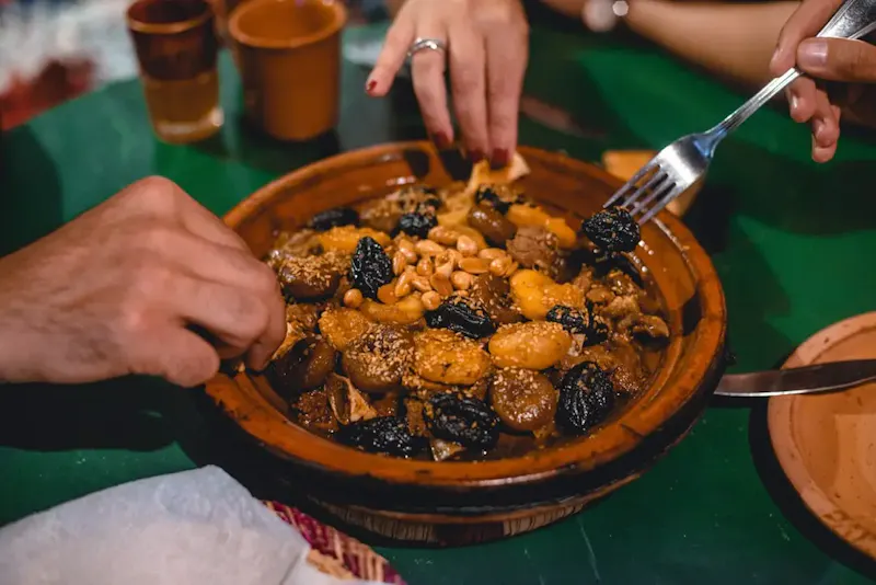 Photo de La Table du Maroc a person eating a bowl of food | Photo de sour moha, sur https://unsplash.com/@sour_moha?utm_source=centralapp&utm_medium=referral