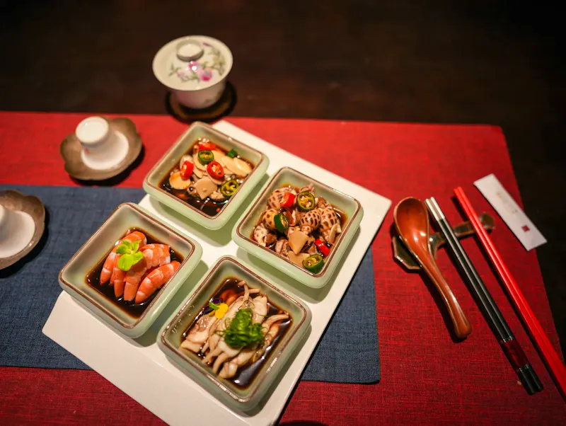 Image of Mad Ristorante e Bar Top view of an elegant Asian seafood meal setting with various dishes and utensils. | Photo by 易亚彬, on https://www.pexels.com/@495879388?utm_source=CentralApp&utm_medium=referral