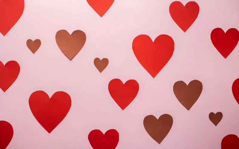 Cutout paper heart stickers glued on pink background symbolizing romantic Valentines Day celebration | Immagine di Monstera Production, su https://www.pexels.com/@gabby-k?utm_source=centralapp&utm_medium=referral