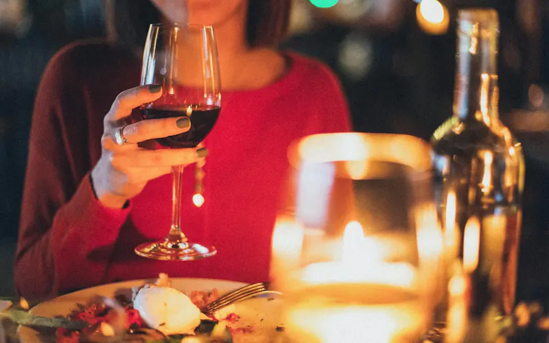 A woman enjoying red wine at a romantic candlelit dinner, perfect for celebrations. | Immagine di Elina Sazonova, su https://www.pexels.com/@elina-sazonova?utm_source=centralapp&utm_medium=referral
