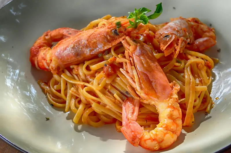 Close-up of a flavorful seafood pasta dish with king prawns, perfectly cooked with Italian flavors. | Photo by Dana Tentis, on https://www.pexels.com/@dana-tentis-118658?utm_source=centralapp&utm_medium=referral