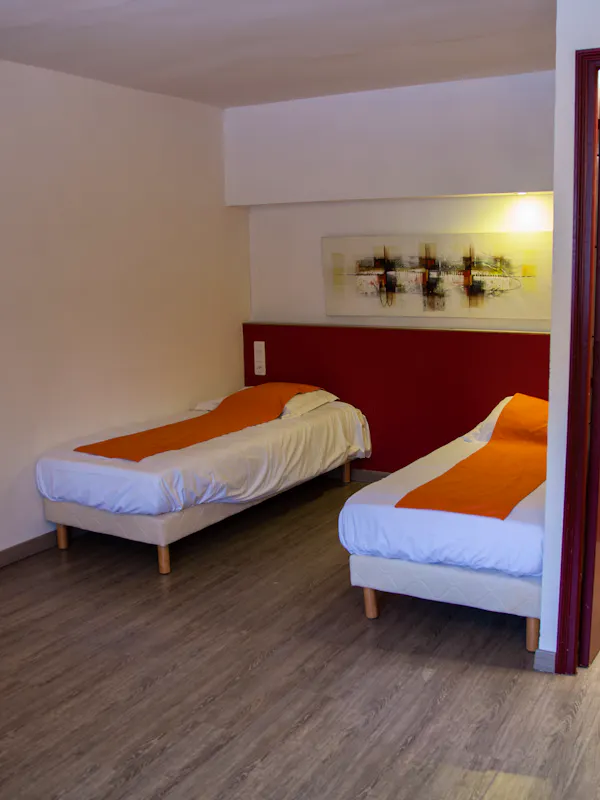 Chambre confortable pour quatre personnes, équipée de 4 lits simples ou de 2 lits simples et d’un lit superposé, avec salle de bain et toilettes privatives. Petit-déjeuner inclus.