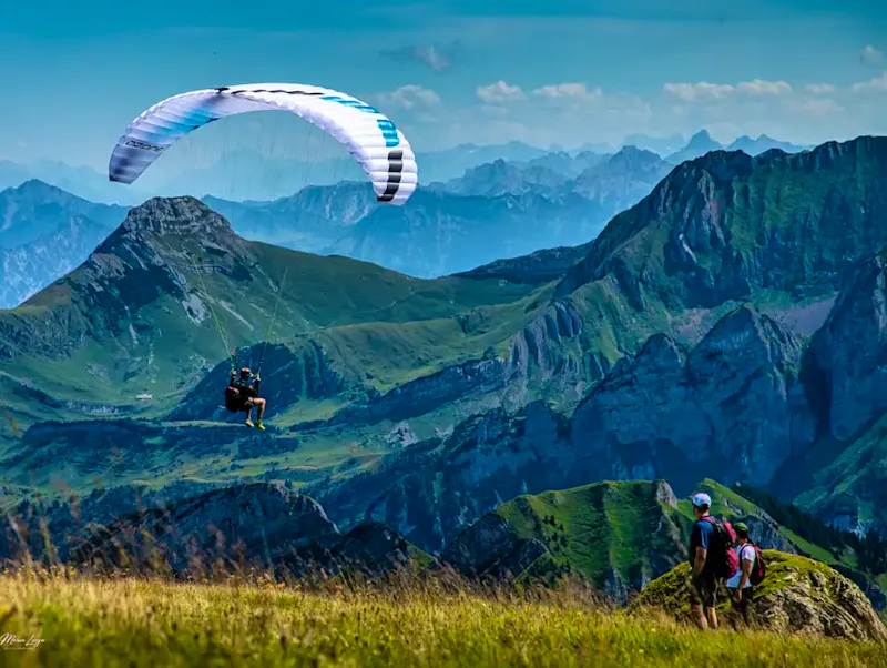 Photo de Kiss & Fly Two people are paragliding over a mountain range | Photo de Maria Luiza Sfetcu, sur https://unsplash.com/@marialuizasfetcu?utm_source=CentralApp&utm_medium=referral