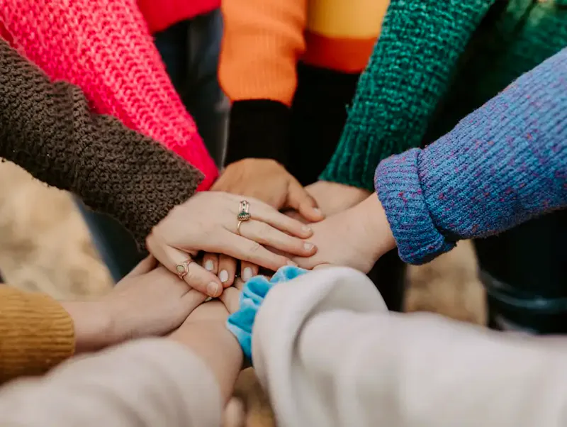person in red sweater holding babys hand | Immagine di Hannah Busing, su https://unsplash.com/@hannahbusing?utm_source=centralapp&utm_medium=referral
