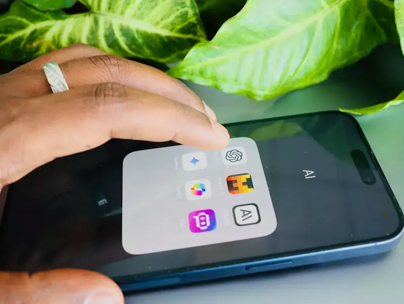 a person holding a cell phone with icons on the screen | Photo de Solen Feyissa, sur https://unsplash.com/@solenfeyissa?utm_source=centralapp&utm_medium=referral