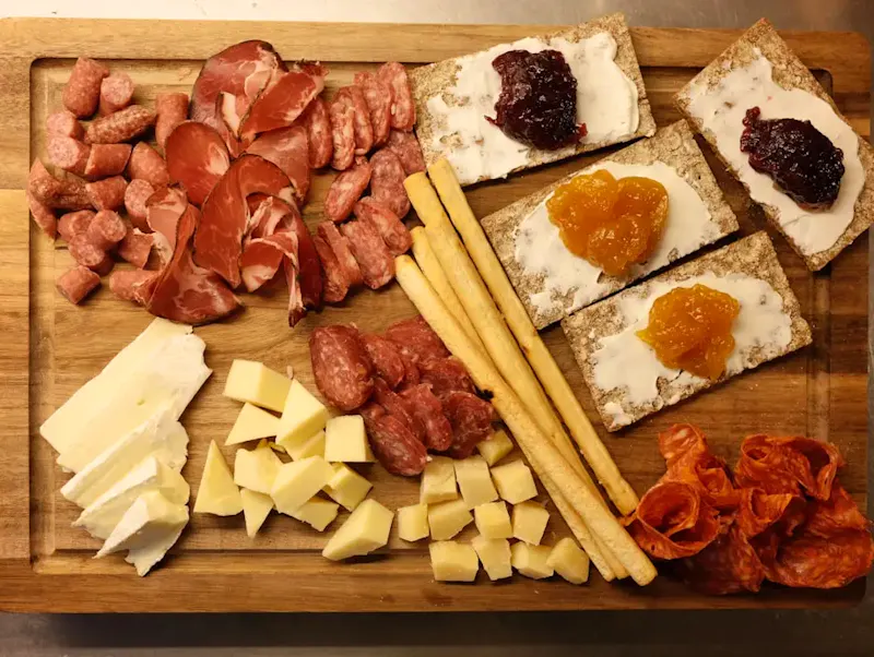 Charcuterie board with cheese, meats, crackers, and jam. | Photo by Enis, on https://unsplash.com/@paparutzu?utm_source=CentralApp&utm_medium=referral