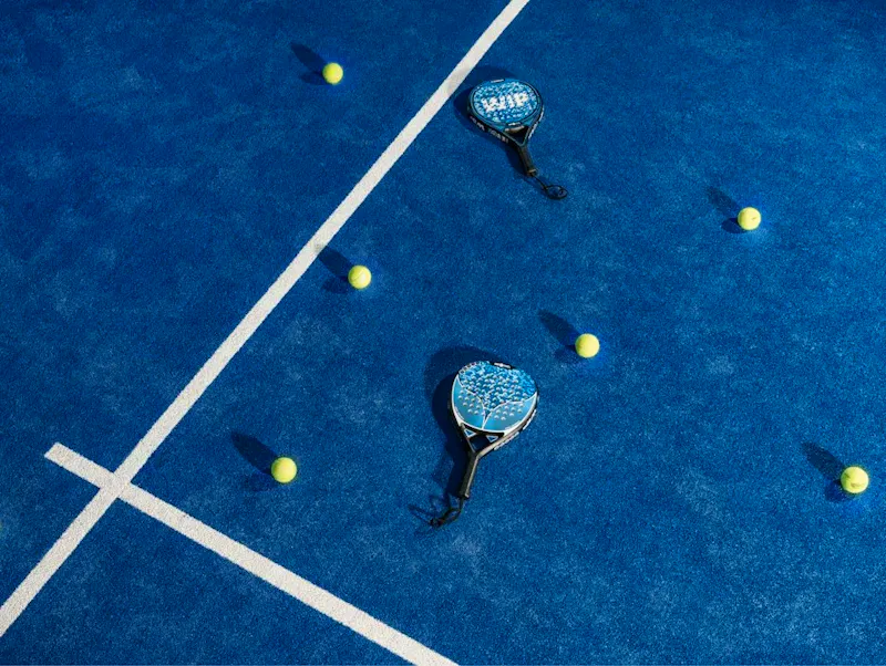 two tennis rackets and balls on a blue tennis court | Photo by Vincenzo Morelli, on https://unsplash.com/@vincenzomorelli?utm_source=CentralApp&utm_medium=referral