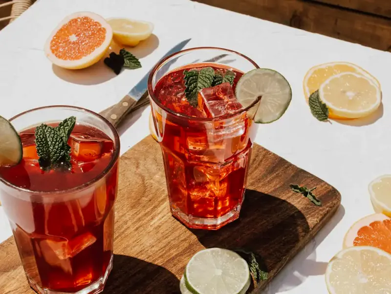 two clear drinking glasses with filled red liquid | Foto de Katherine Sousa, en https://unsplash.com/@ksousaphotography?utm_source=CentralApp&utm_medium=referral