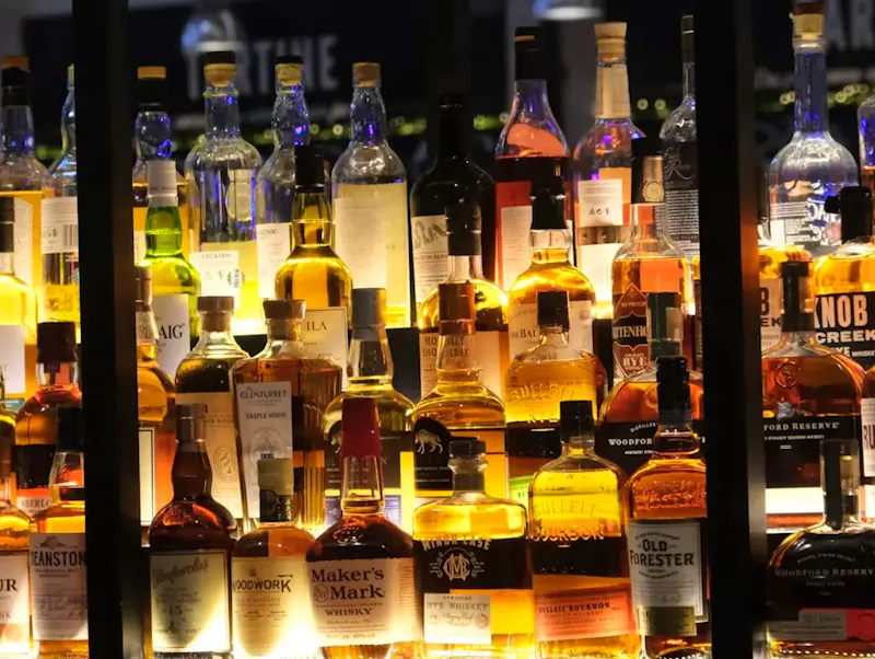 a display case filled with lots of bottles of liquor | Photo de Kai Vu, sur https://unsplash.com/@kaivu?utm_source=centralapp&utm_medium=referral