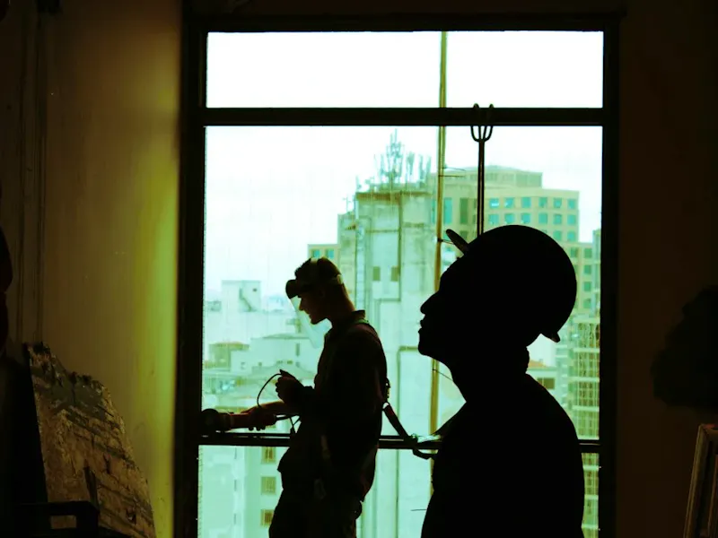 two men wearing hard hat standing near clear glass window | Photo de Guilherme  Cunha, sur https://unsplash.com/@guiccunha?utm_source=centralapp&utm_medium=referral